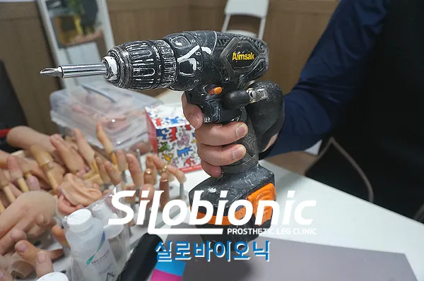 티타늄 반자동 의수로 전동 드릴을 잡은 모습
