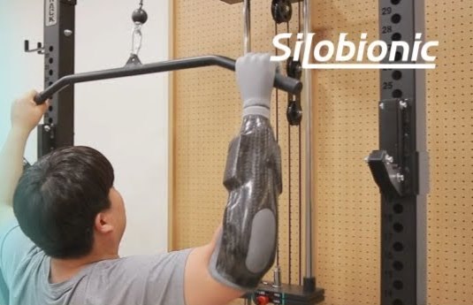 전자의수를 착용하고 운동 기구 손잡이를 당기는 고객님