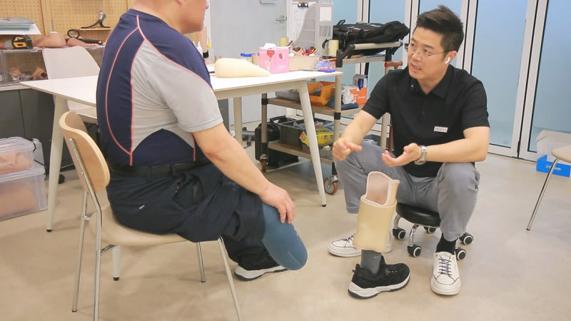 의족 소켓을 들고 고객님께 설명하는 전문가