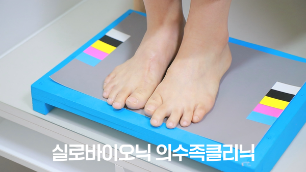 양쪽 컬러차트가 있는 발판 위에 선 두 발