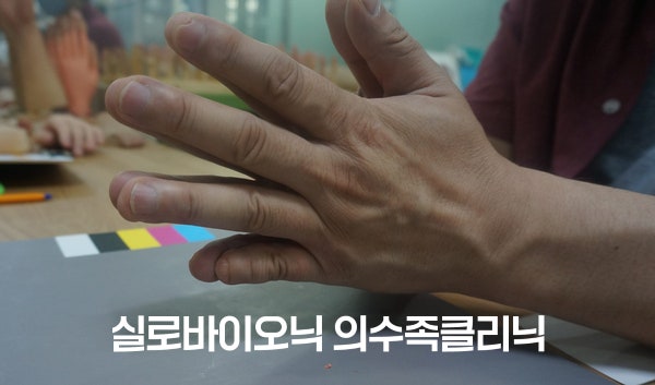 컬러차트 옆에 놓인, 새끼손가락이 짧은 손