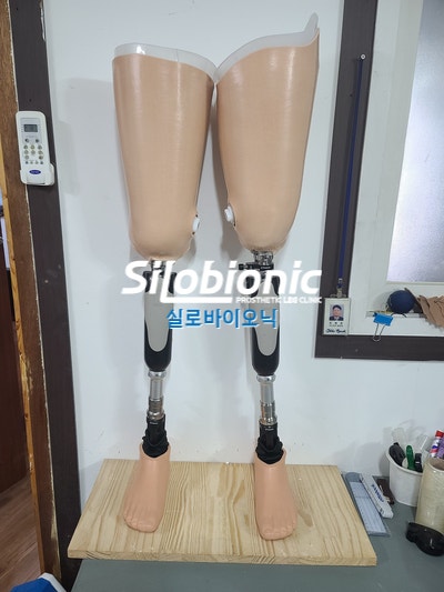 나무 받침 위에 나란히 세워 둔 대퇴 의족 두 벌