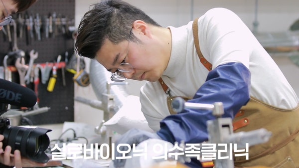 작업대에서 다리 의족 부품을 조립하는 실로바이오닉 제작 전문가
